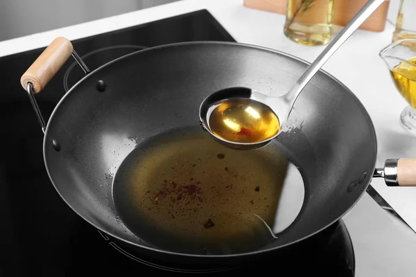 Wok et louche avec huile végétale usagée dans la cuisine — Photo