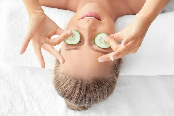 Young woman with cucumber slices in spa salon — Stock Photo, Image