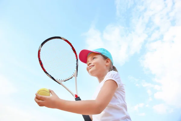 テニス ラケットとボールの空を背景にかわいい女の子 — ストック写真