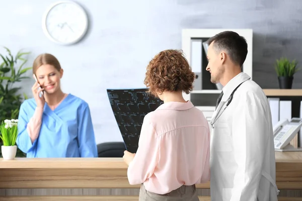 Recepcionista e médico com cliente no hospital — Fotografia de Stock