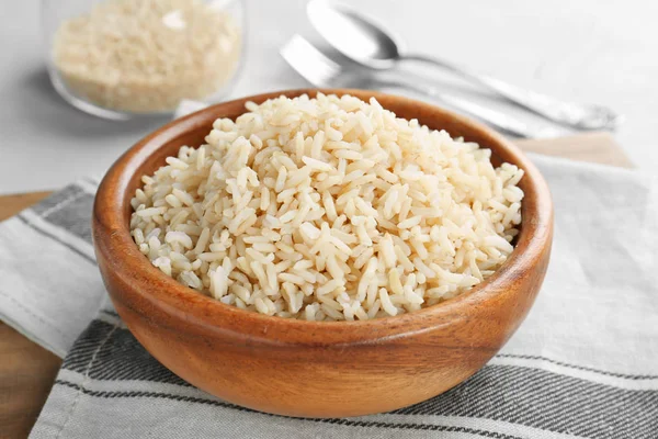 Bowl with cooked rice on table