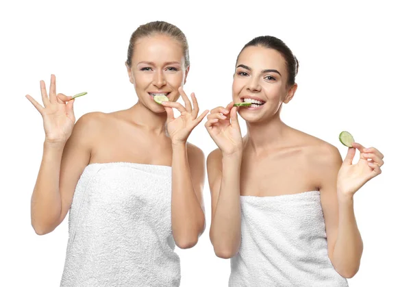 Mulheres jovens com fatias de pepino no fundo branco — Fotografia de Stock