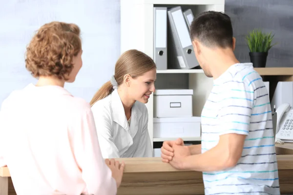 Giovane receptionist femminile con clienti in ospedale — Foto Stock