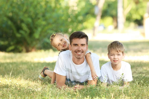 Vader met kinderen in het park op zonnige dag — Stockfoto