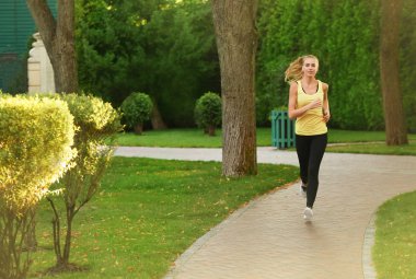 Yeşil park çalışan genç sportif kadın