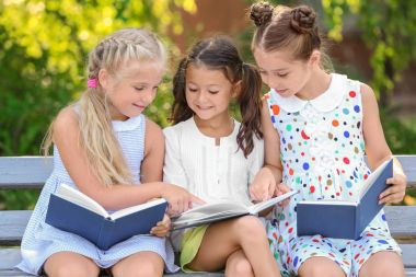 Sevimli küçük çocuklar Park kitap okuma