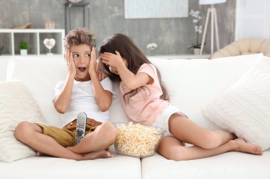 Şirin çocuk evde kanepede televizyon izlerken