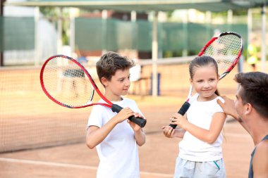 Tenis kortunda Küçük çocuklu genç eğitmeni