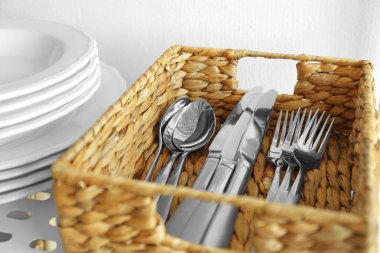 Cutlery in wicker basket on shelf clipart
