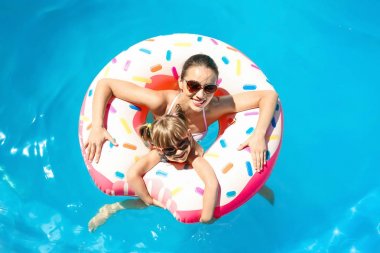 Genç bir kadın ve kızı ile Yüzme havuzunda şişme çörek