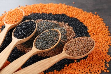 Mercimek ve tahta kaşıklar gri arka plan üzerinde farklı ile kompozisyon