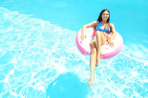年轻美丽的女人在游泳池充气环日光浴 — 图库照片