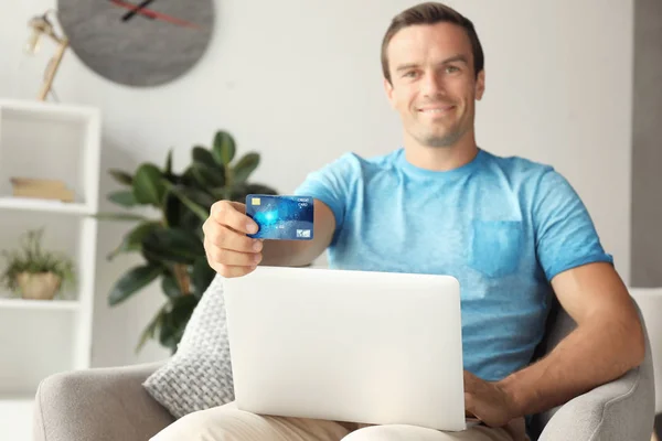 Człowiek z posiadania karty kredytowej wewnątrz laptopa — Zdjęcie stockowe