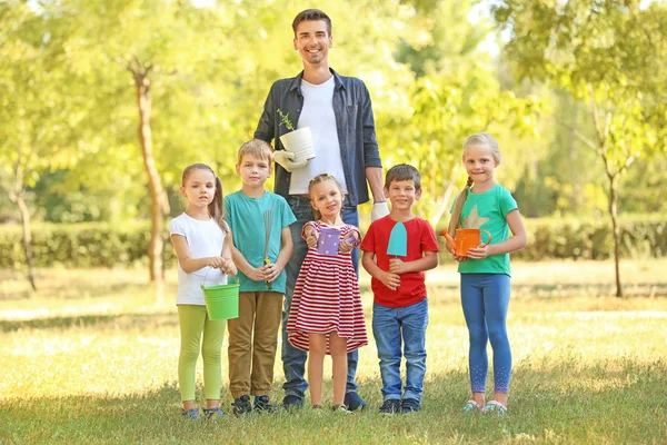 Grupo de niños con maestra en el parque en un día soleado — Foto de Stock