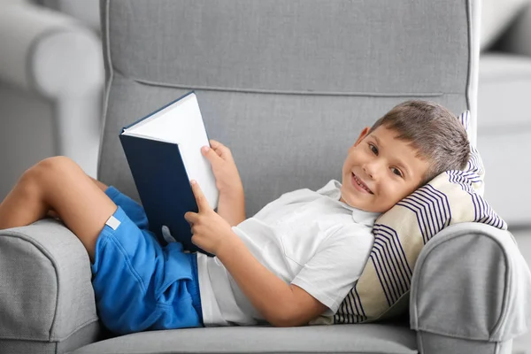 Милый маленький мальчик читает дома книги — стоковое фото