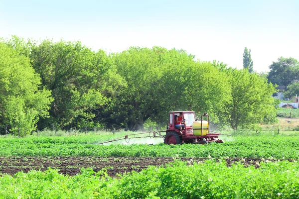 Traktor penyemprotan lapangan dengan tanaman hijau — Stok Foto