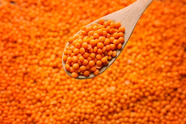 Cucchiaio con lenticchie rosse su fondo sfocato — Foto Stock