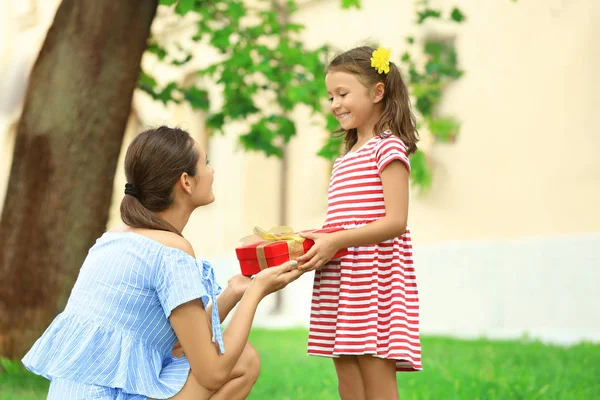 Mor presentera presentask till hennes dotter i park sommardag — Stockfoto