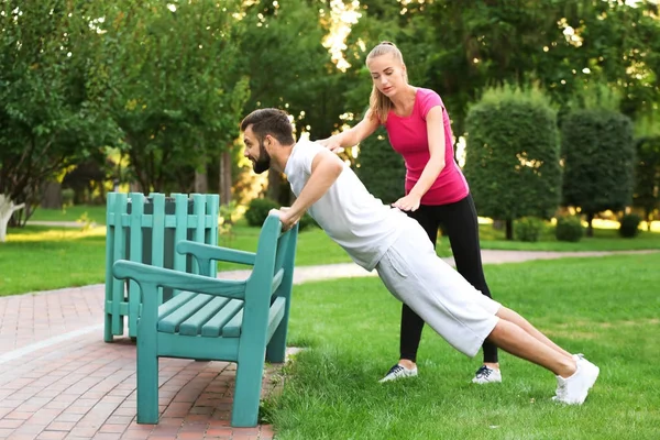 Sportieve jongeman met trainer — Stockfoto