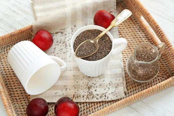 Chia seeds in cup and jug on wicker tray — Stock Photo, Image