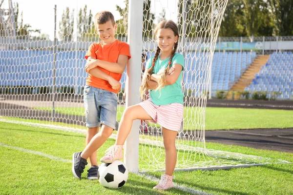 Милые дети с футбольным мячом на поле — стоковое фото