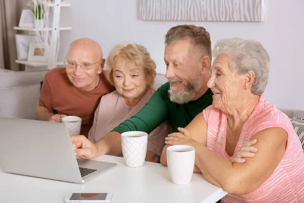 Skupina starších lidí s notebookem doma — Stock fotografie