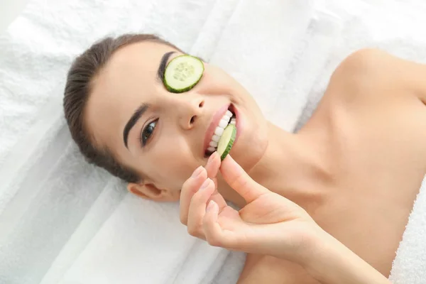 Young woman with cucumber slices — Stock Photo, Image