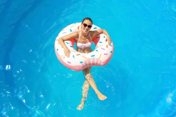Jonge vrouw met opblaasbare donut — Stockfoto