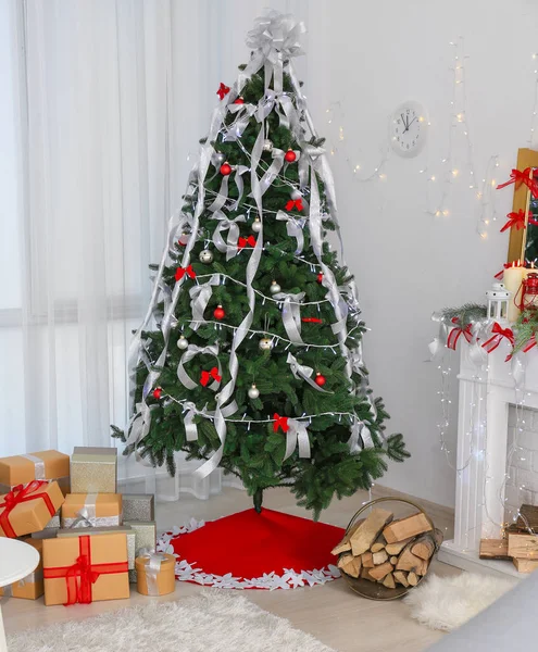 Beautiful Christmas tree with skirt and gifts at home — Stock Photo, Image