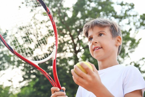 Sevimli küçük çocuk tenis kortunda oynamaya