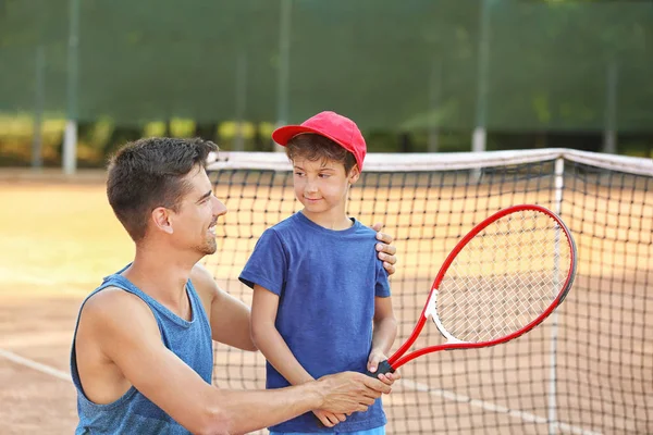 テニスコートで男の子と若いトレーナー — ストック写真