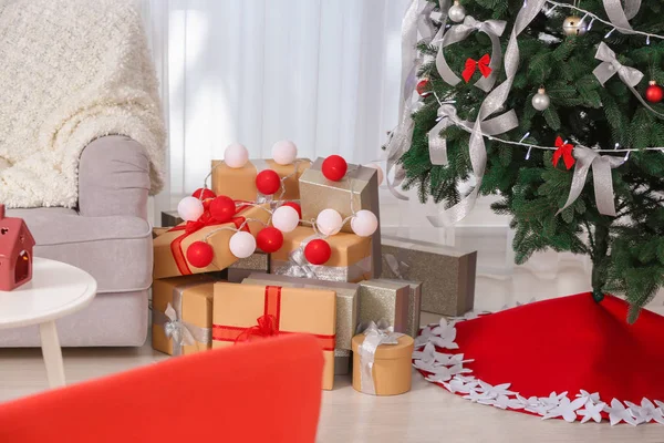 Hermoso árbol de Navidad con falda y regalos en casa — Foto de Stock