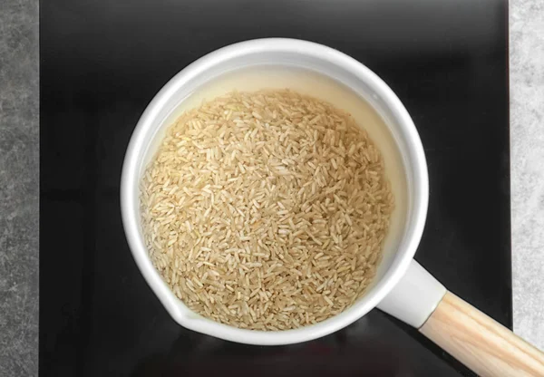 Tencereye su mutfak ve çiğ pirinç — Stok fotoğraf