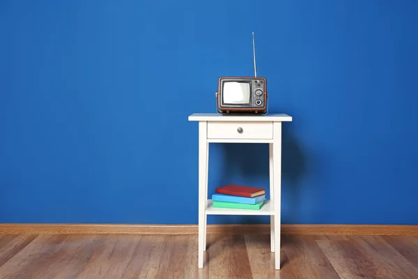 Kleine oude Tv op tafel tegen kleur muur — Stockfoto