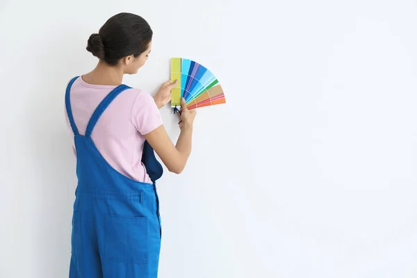 Vrouwelijke decorateur houden kleurenpalet monsters op witte achtergrond — Stockfoto