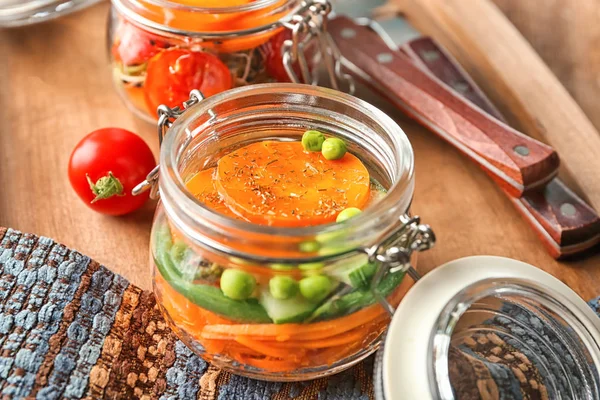 Pot avec salade de carottes savoureuse sur planche en bois — Photo