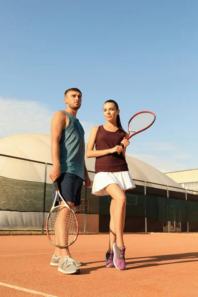 Mladý pár s tenisové rakety — Stock fotografie