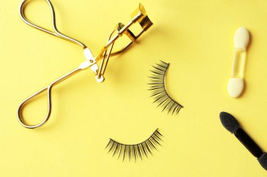 Kirpik kıvırıcı ve yanlış ile kompozisyon 