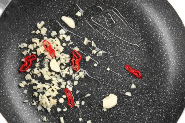 Yemeklik yağ, kıyılmış sarımsak ve biber kızartma tavası üzerinde