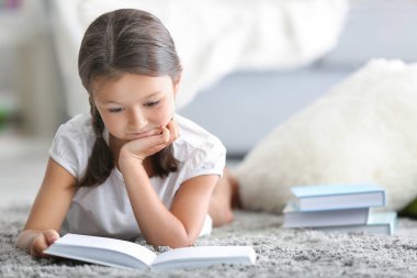 Kitap okuyan sevimli küçük bir kız. 