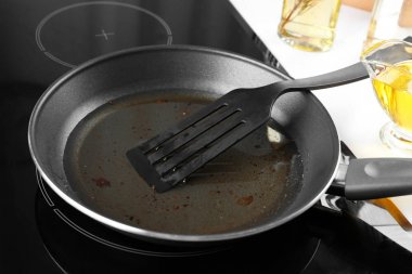 Kullanılmış bitkisel yağ ve ocakta spatula ile kızartma tavası