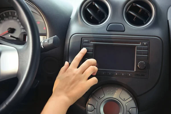 Woman tuning radio in car — Stock Photo, Image