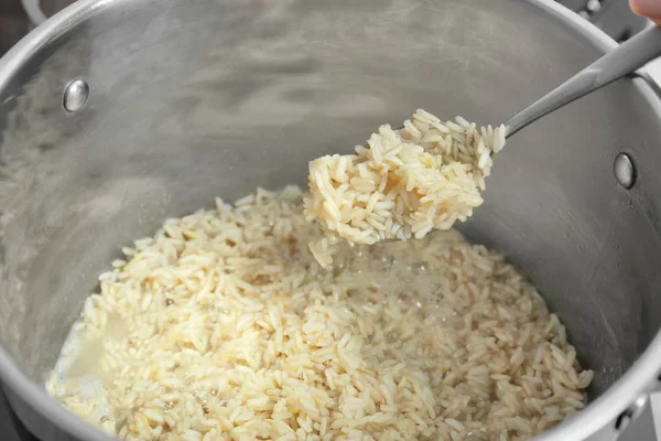 Kaşıkla tenceresi yukarıda haşlanmış pirinç