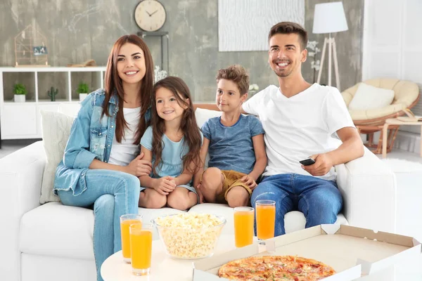 Família feliz assistindo TV no sofá em casa — Fotografia de Stock