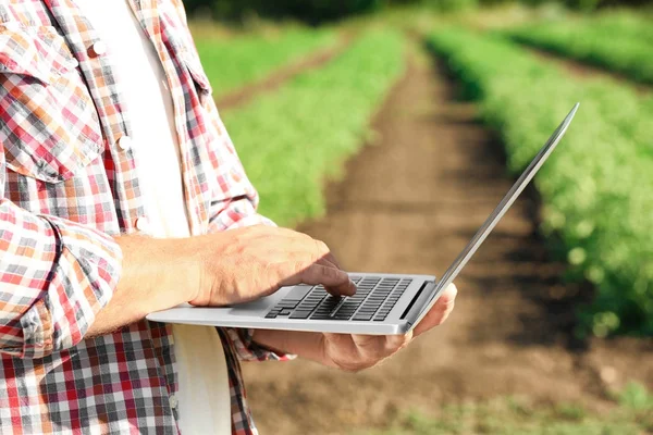 Agricultor usando portátil en el campo — Foto de Stock