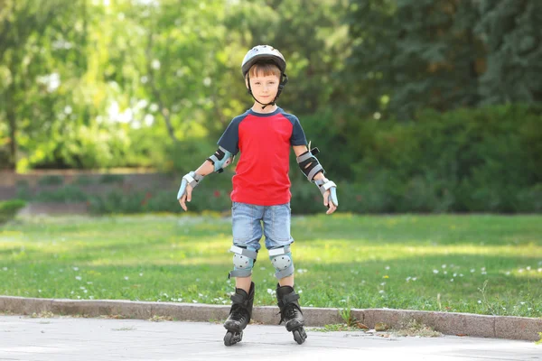 Милый мальчик катается на роликах в парке — стоковое фото