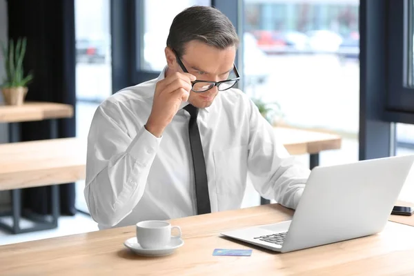 Joven hombre de negocios usando portátil en el lugar de trabajo — Foto de Stock