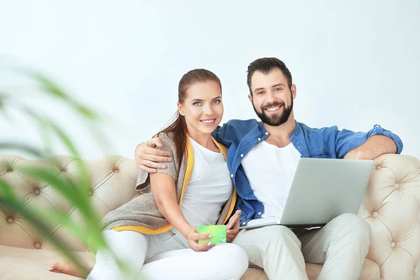 Jeune couple avec ordinateur portable à la maison. Concept de magasinage Internet — Photo