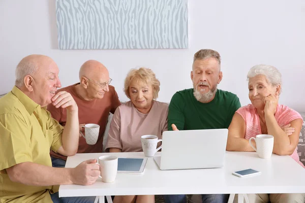 Skupina starších lidí s notebookem doma — Stock fotografie