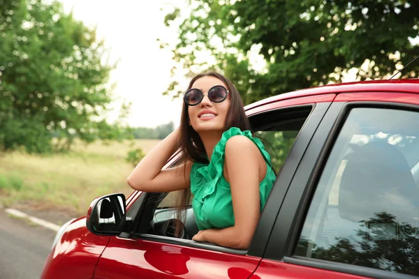 Femme regardant par la fenêtre de la voiture — Photo